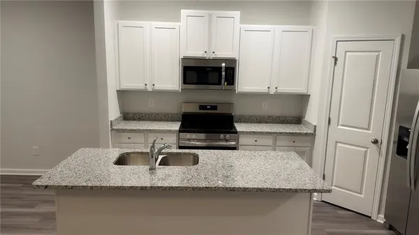 a kitchen with granite countertop a sink and a stove