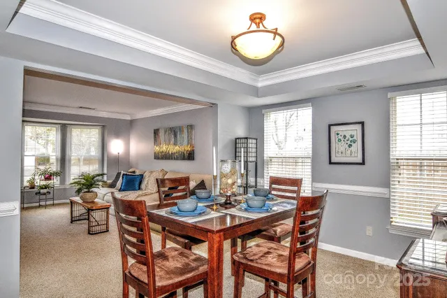 a view of a dining room and livingroom with furniture wooden floor and a large window