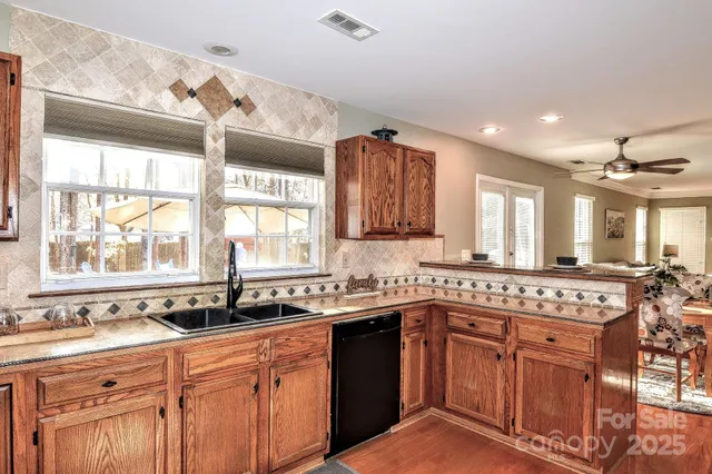 a kitchen with stainless steel appliances granite countertop a sink stove and cabinets