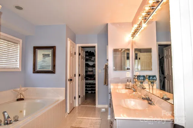 a bathroom with a tub a sink and a window