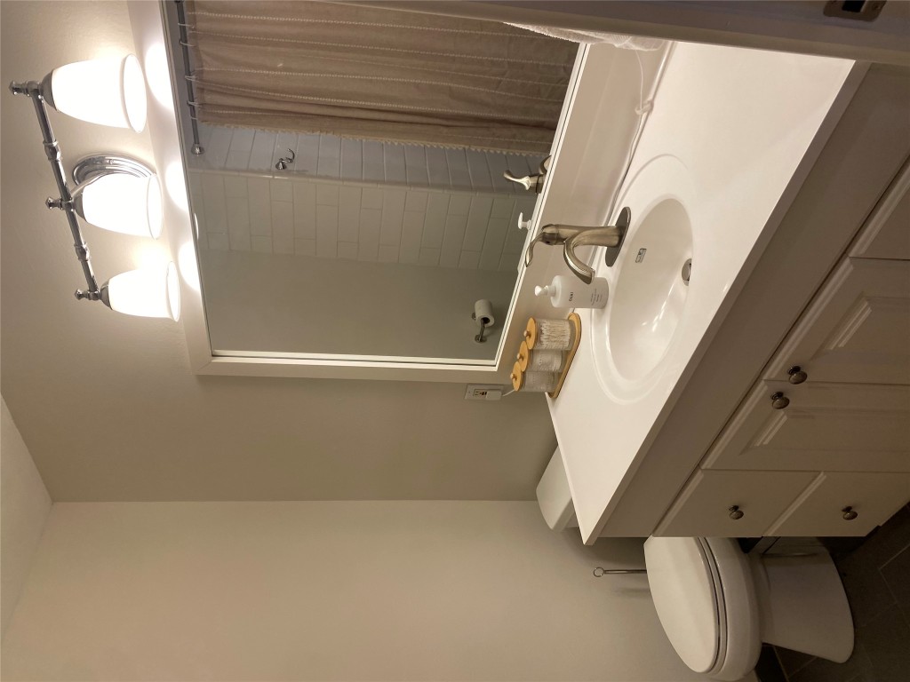 2414 South 5th Street, Unit A Austin, TX 78704 - Photo 13 of 18 a bathroom with a sink a toilet and mirror