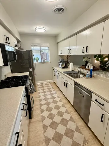 a kitchen with a sink appliances and cabinets
