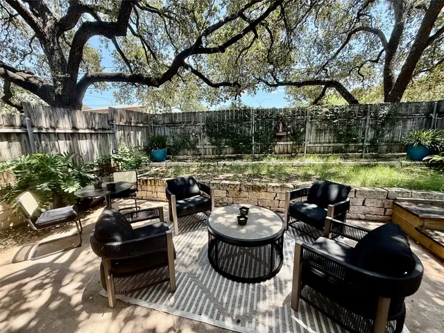 a view of a patio with couches table and chairs and potted plants