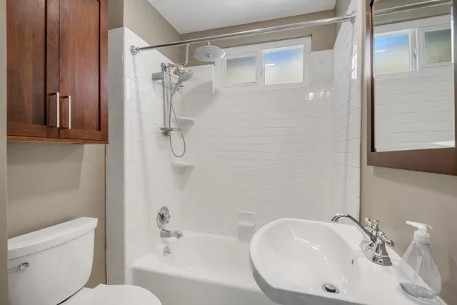 a bathroom with a sink a toilet and shower