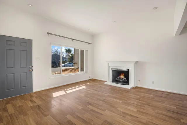 a view of an empty room with window and fire place