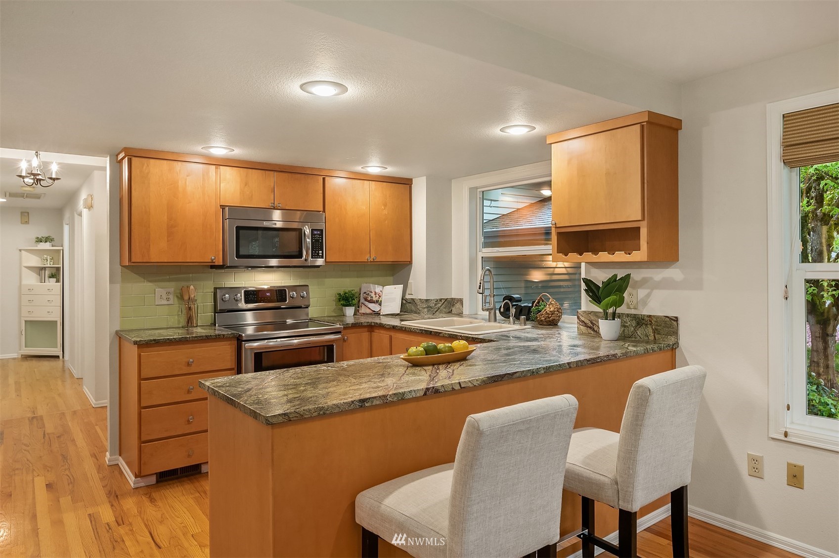 6730 114th Avenue Southeast Bellevue, WA 98006 - Photo 15 of 32 a kitchen with stainless steel appliances granite countertop a sink a stove a refrigerator cabinets and chairs