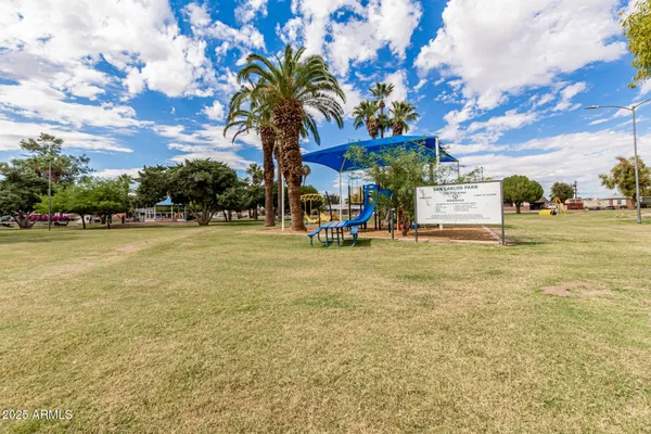 a view of a swimming pool with lawn chairs under an umbrella