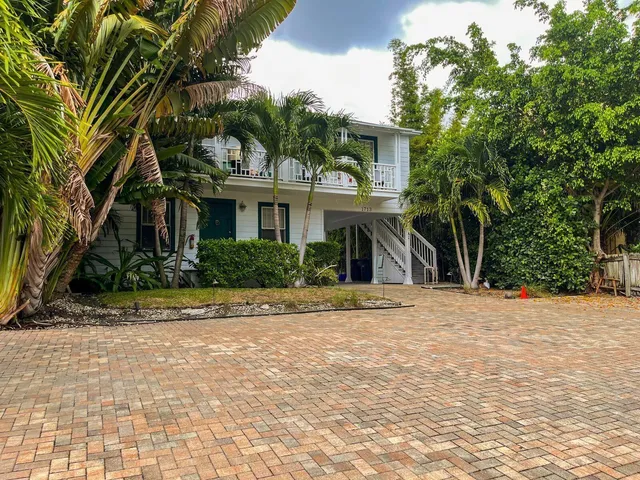 a front view of a house with a yard and potted plants
