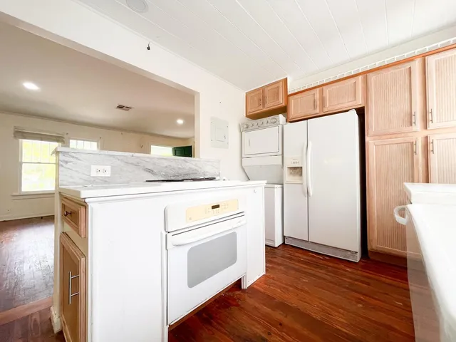 a kitchen with kitchen island wooden floor white cabinets and stainless steel appliances