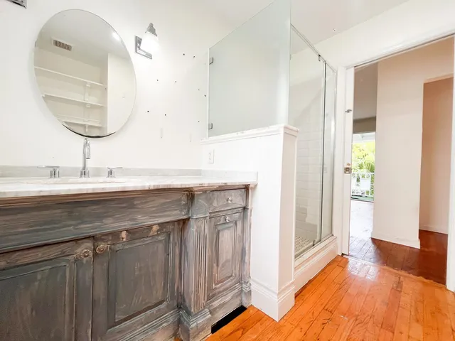 a en suite bathroom with a granite countertop sink and a mirror