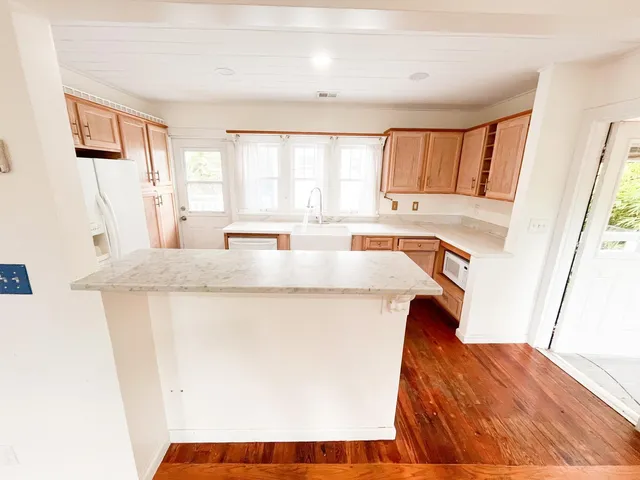 a kitchen with stainless steel appliances granite countertop a sink and a refrigerator
