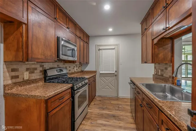 a kitchen with a stove sink and cabinets