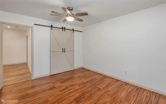 a view of an empty room with wooden floor