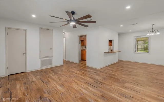a view of empty room with wooden floor and window