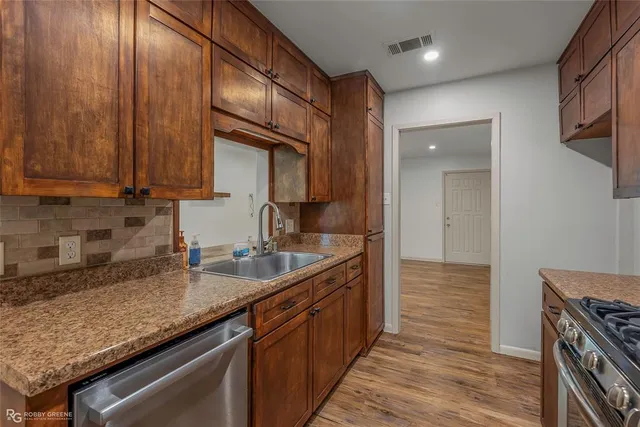 a kitchen with granite countertop a sink stove and cabinets