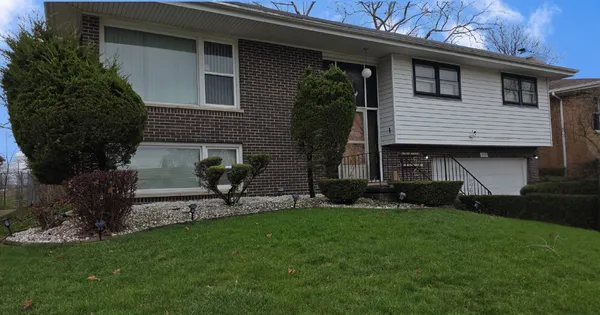 a front view of a house with a garden and plants
