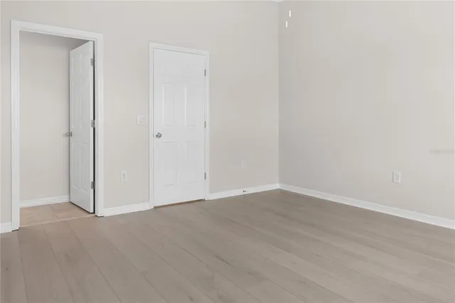 a view of an empty room with wooden floor
