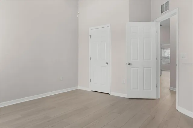 a view of an empty room with wooden floor