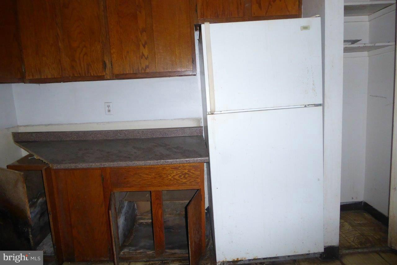 7957 Riggs Road, Unit 2 Hyattsville, MD 20783 - Photo 6 of 17 a view of a refrigerator in kitchen and an empty room