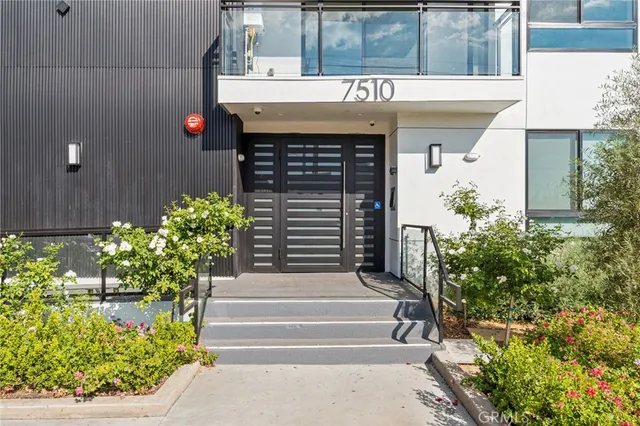 a front view of a house with plants