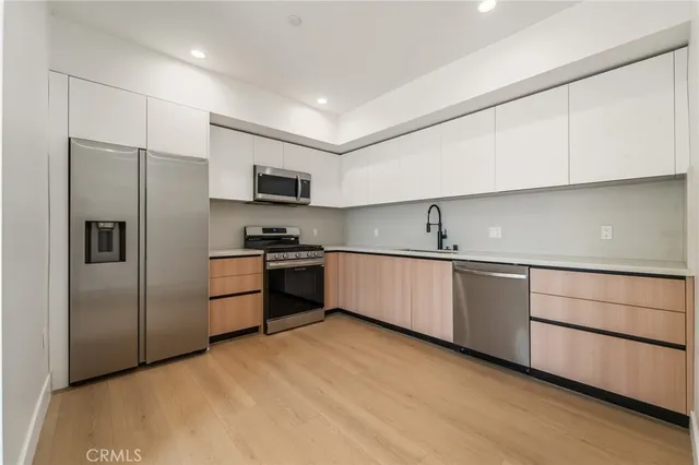 a kitchen with granite countertop a refrigerator and a sink