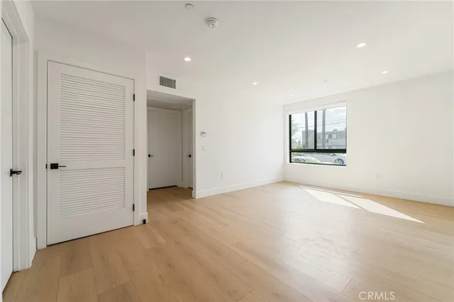 an empty room with windows and closet