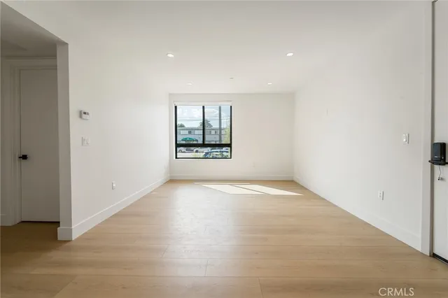 an empty room with a window and wooden floor