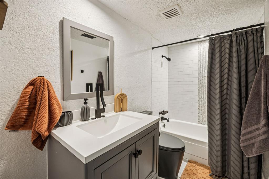 3601 Colosseum Way Grand Prairie, TX 75052 - Photo 13 of 28 a bathroom with a sink a mirror and a shower