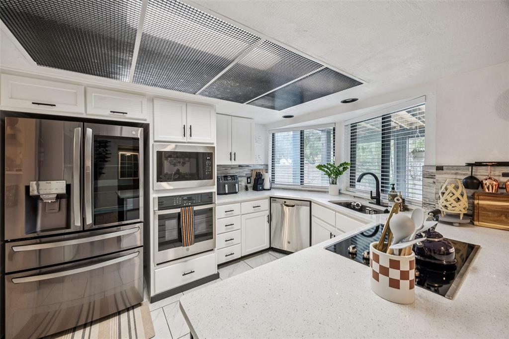 3601 Colosseum Way Grand Prairie, TX 75052 - Photo 17 of 28 a kitchen with stainless steel appliances kitchen island granite countertop a stove refrigerator and cabinets