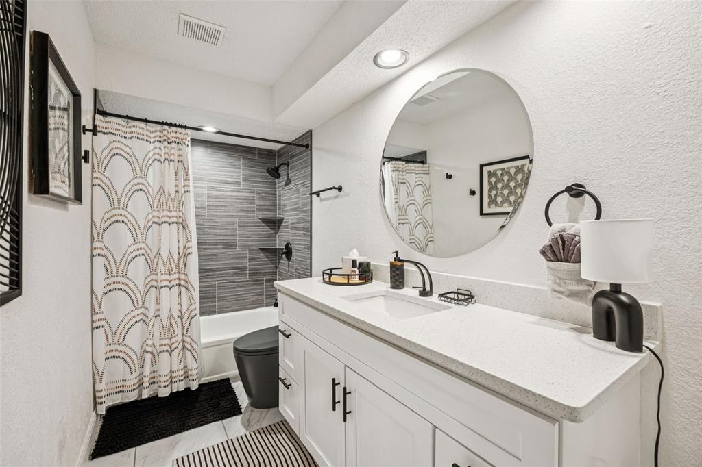 3601 Colosseum Way Grand Prairie, TX 75052 - Photo 24 of 28 a bathroom with a sink a toilet and a mirror