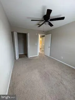 a view of a livingroom with a ceiling fan and window