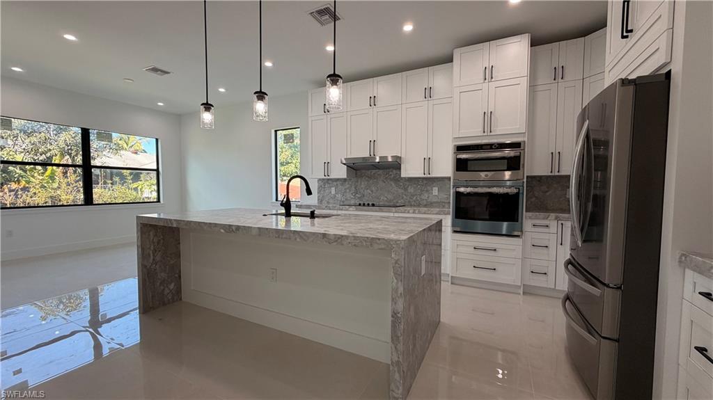 4710 Acadia Lane Naples, FL 34112 - Photo 3 of 10 a kitchen with stainless steel appliances a refrigerator sink and stove