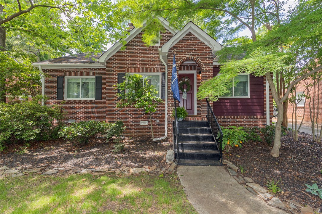 This charming brick home features classic architectural details and lush landscaping.