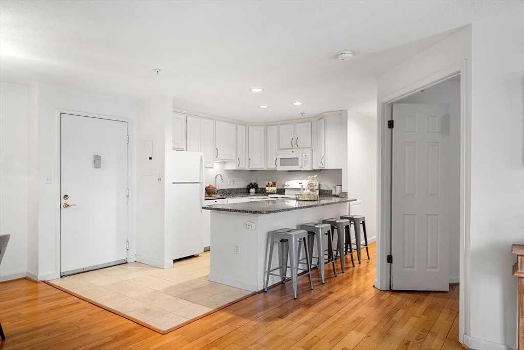 11 Church Street, Unit 203 Salem, MA 01970 - Photo 5 of 40 a kitchen with stainless steel appliances granite countertop a stove top oven a sink and a refrigerator