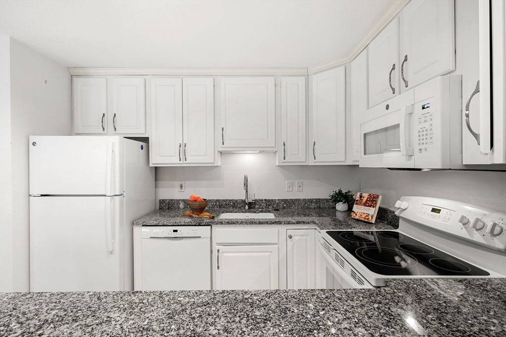 11 Church Street, Unit 203 Salem, MA 01970 - Photo 6 of 40 a kitchen with granite countertop white cabinets and refrigerator