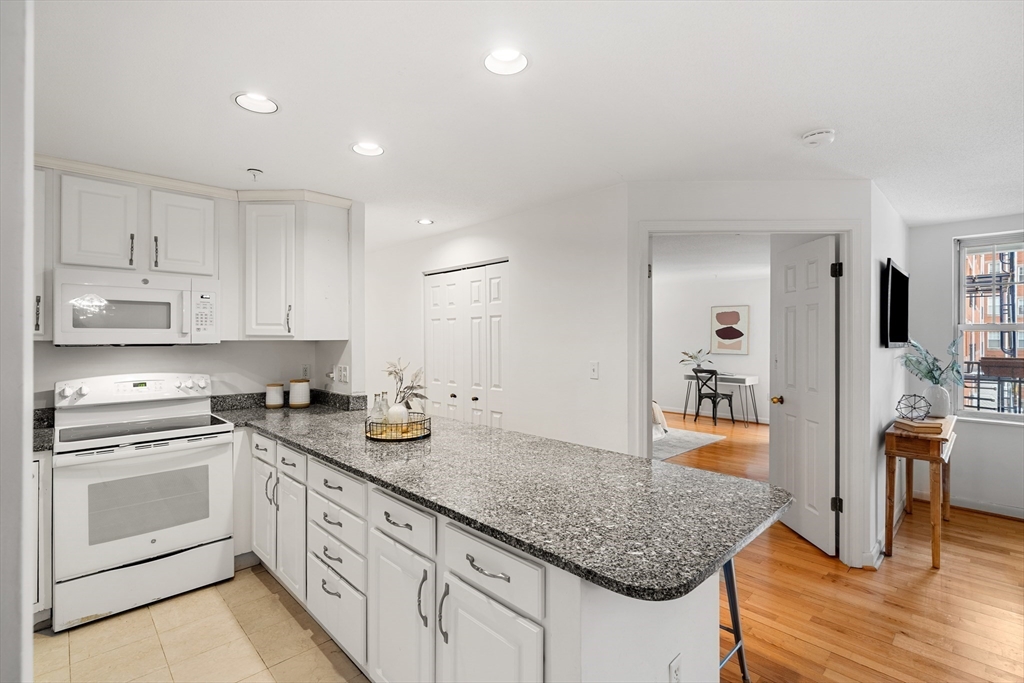 11 Church Street, Unit 203 Salem, MA 01970 - Photo 7 of 40 a kitchen with white cabinets and appliances