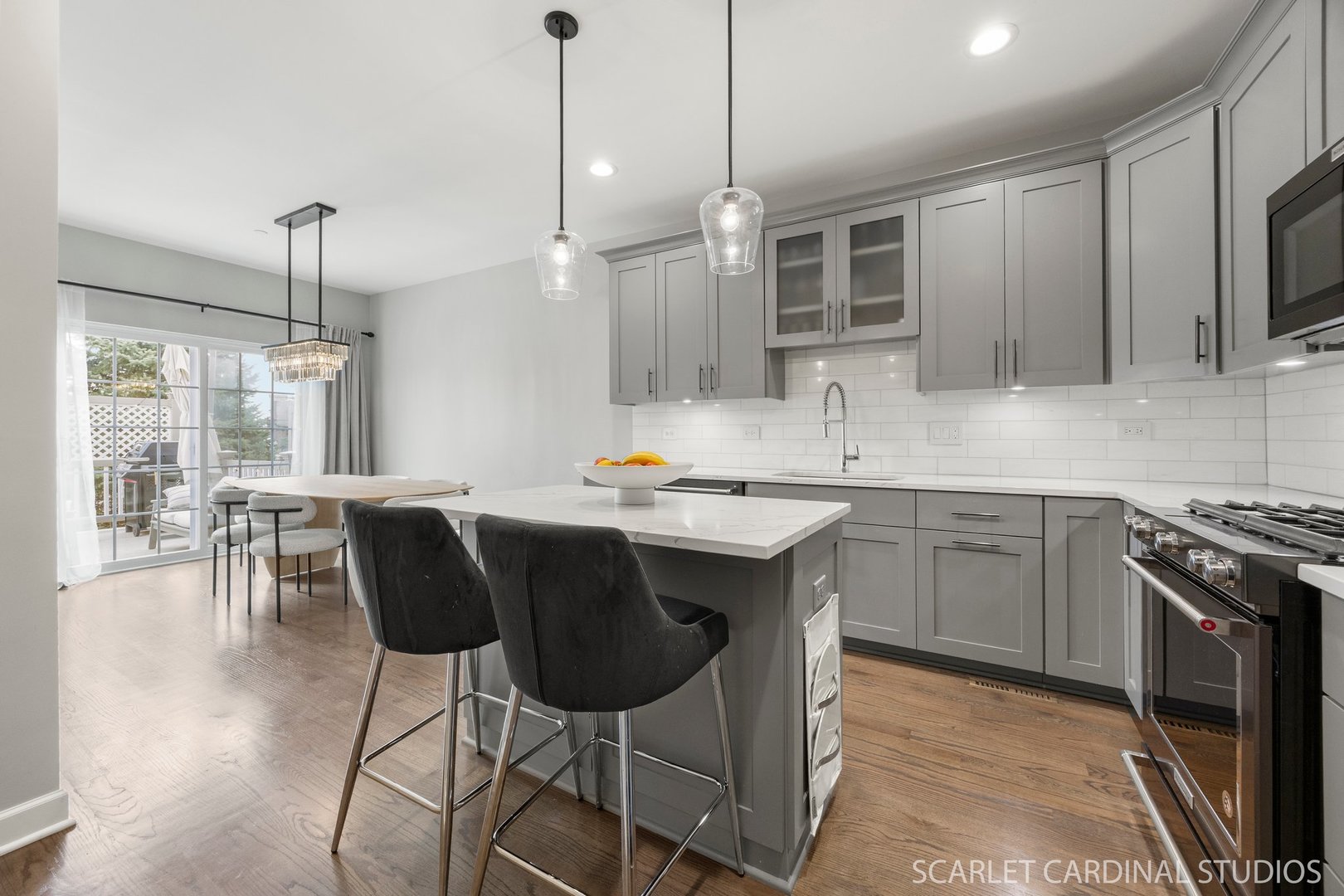 14253 Lacey Drive Lemont, IL 60439 - Photo 4 of 24 a kitchen with stainless steel appliances granite countertop a stove a sink a microwave a dining table and chairs with wooden floor