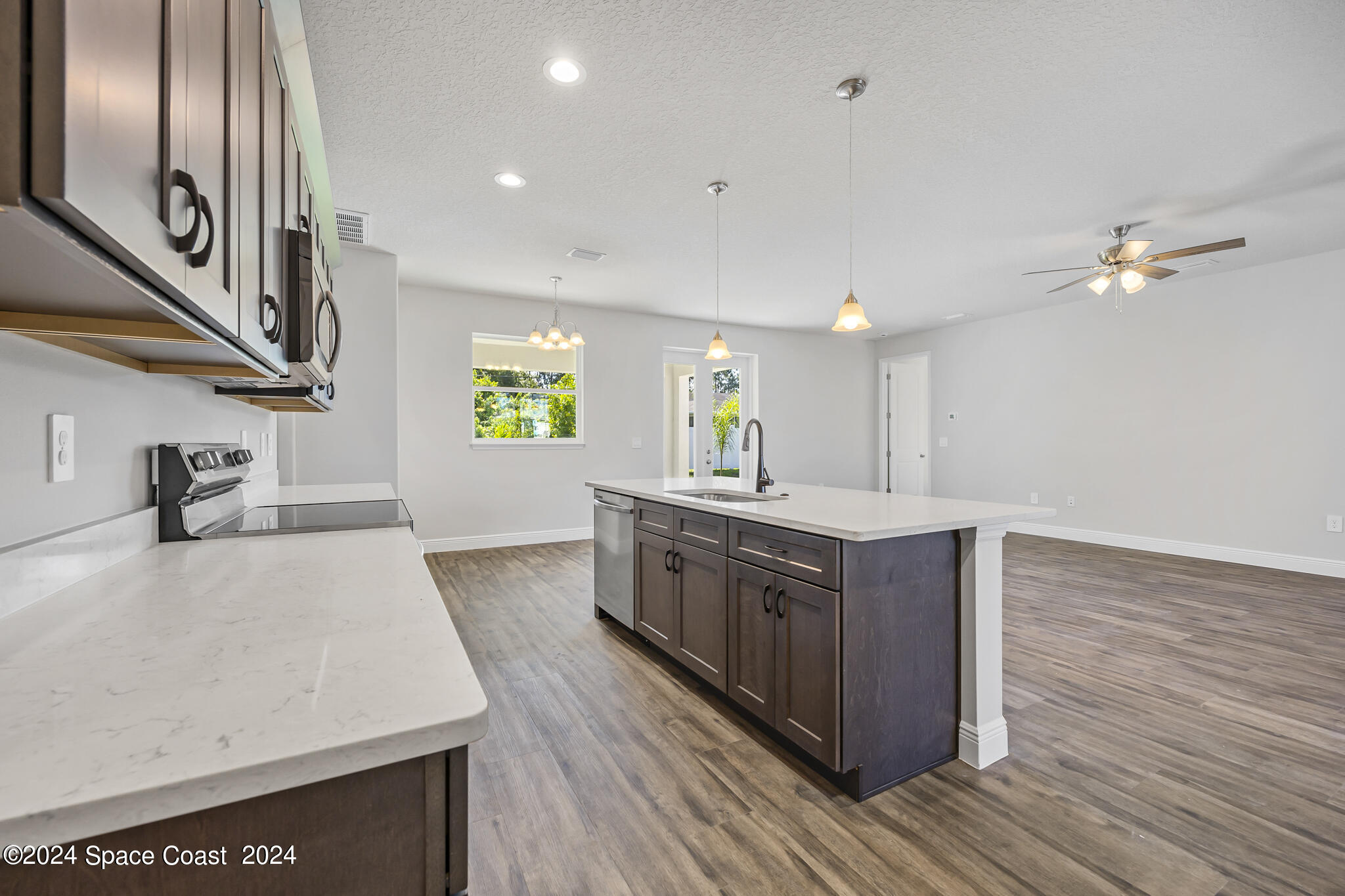 1368 Rabbit Street Southeast Palm Bay, FL 32909 - Photo 25 of 31 a kitchen with stainless steel appliances granite countertop a sink a stove and a wooden floors