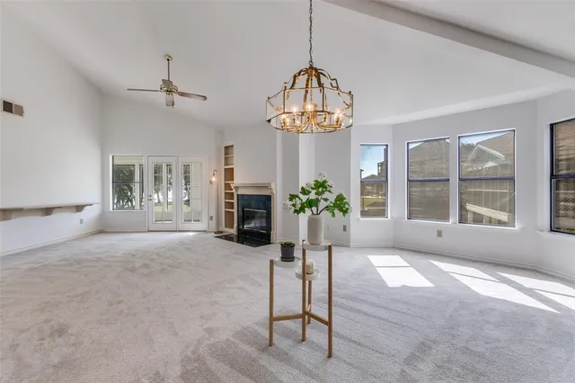a view of an empty room with a window and fireplace