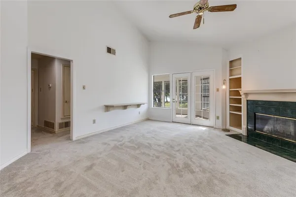 a view of empty room with a fireplace and window
