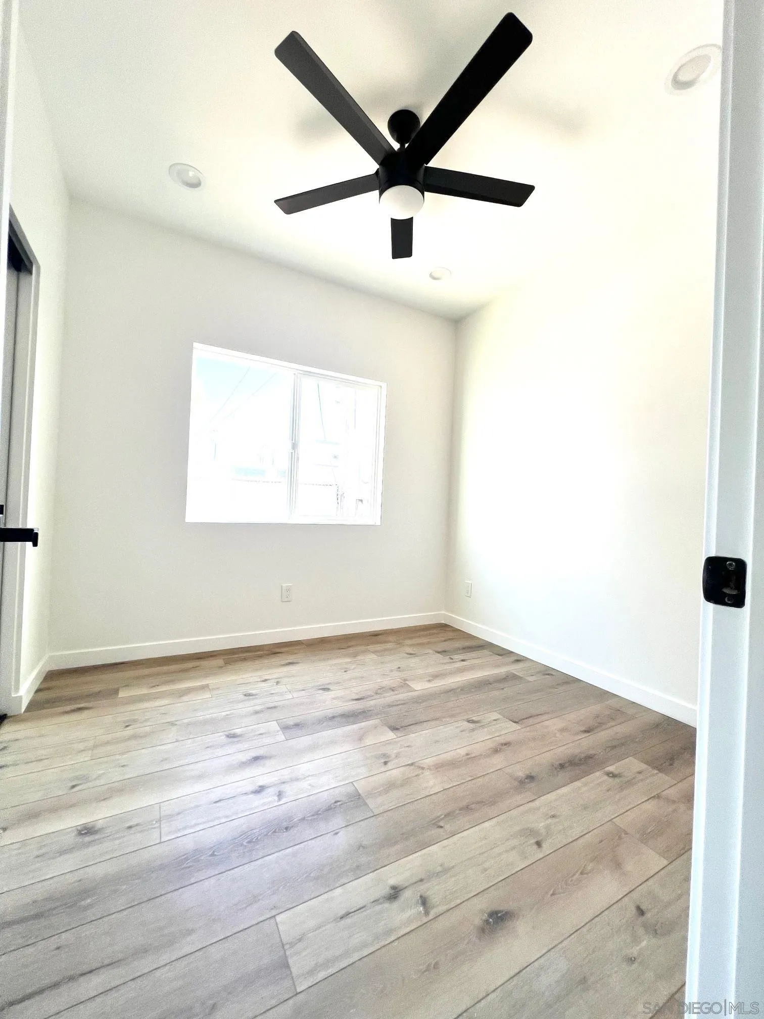 4922 Muir Avenue San Diego, CA 92107 - Photo 25 of 56 an empty room with wooden floor and windows