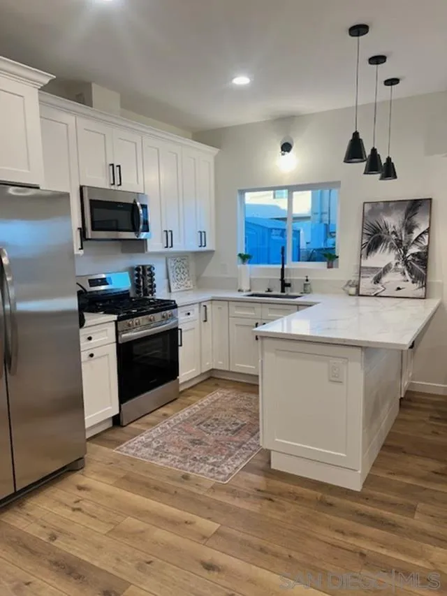 4922 Muir Avenue San Diego, CA 92107 - Photo 33 of 56 a kitchen with stainless steel appliances granite countertop a stove a sink and a refrigerator
