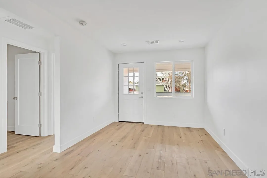 4922 Muir Avenue San Diego, CA 92107 - Photo 7 of 56 an empty room with wooden floor and windows