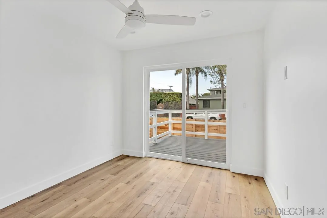 4922 Muir Avenue San Diego, CA 92107 - Photo 8 of 56 an empty room with wooden floor and windows