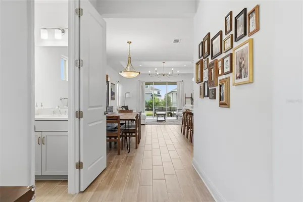 a kitchen with kitchen island granite countertop a stove a sink a dining table and chairs with wooden floor