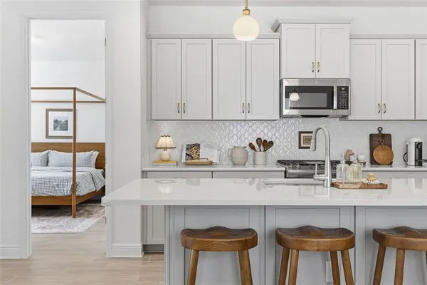 a kitchen with granite countertop a stove a sink a kitchen island with a dining table and chairs