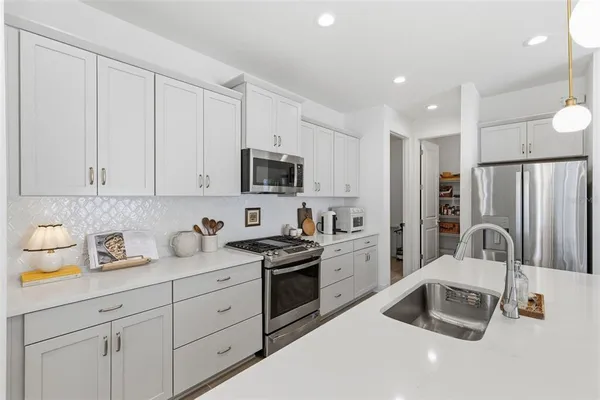 a kitchen with a sink a table and chairs