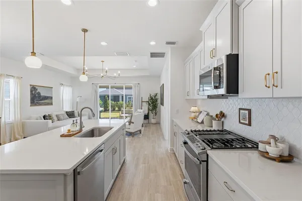 a dining room with wooden floor a chandelier a wooden table and chairs