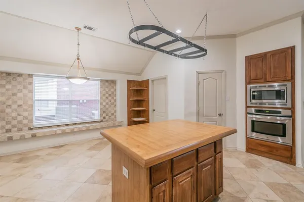 a kitchen with a wooden floor and a refrigerator