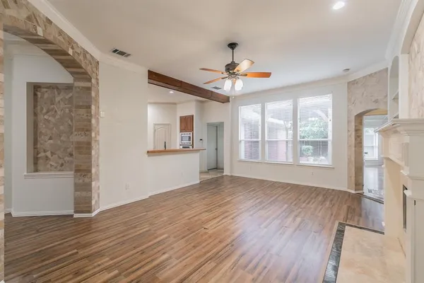 a view of an empty room with window and wooden floor